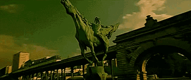a statue of a man riding a horse is in front of a building