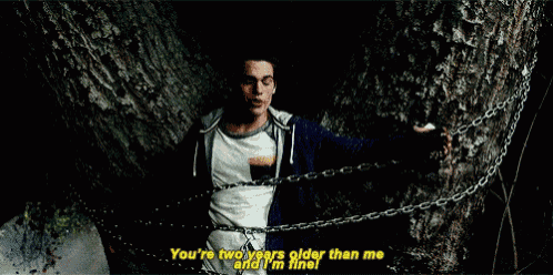 a man is chained to a tree and says " you 're two years older than me and i 'm fine ! "