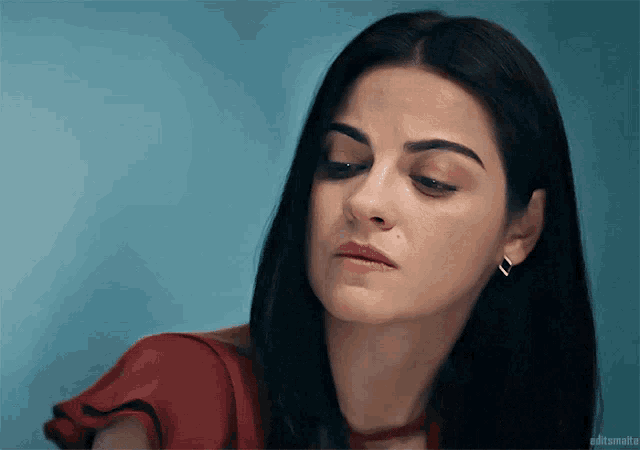 a close up of a woman 's face with a blue background and the words softsmalta on the bottom right