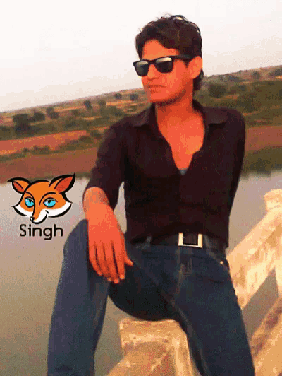 a man wearing sunglasses sits on a ledge with the name singh on the bottom right