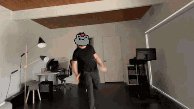 a man in a black shirt is dancing in a room with a cat on his head