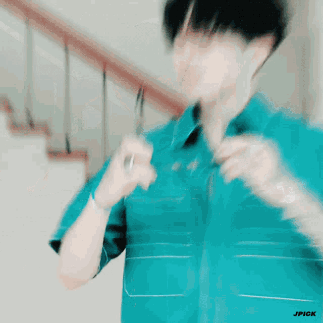 a blurry picture of a man in a blue shirt with jpick written on the bottom right