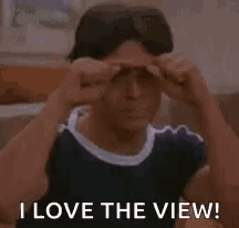 a young man is giving a thumbs up and says i love the view .