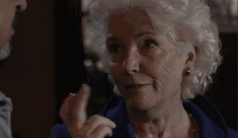 a woman with white hair is making a funny face with her finger