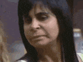 a close up of a woman eating a piece of food with a bottle in the background .