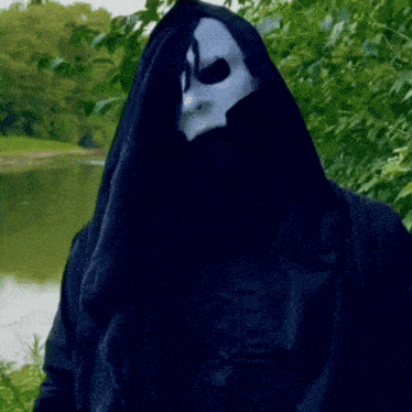 a person wearing a black hooded jacket and a white face mask