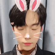 a young man wearing bunny ears and a cat whiskers on his face .