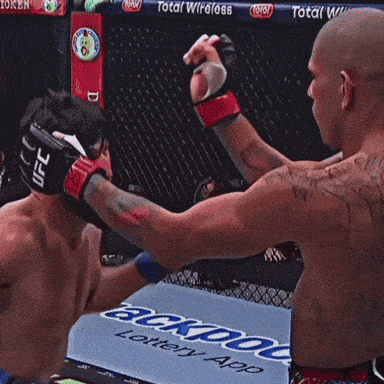 a man wearing a ufc glove is fighting another man in a boxing ring