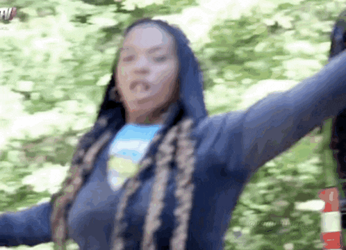 a woman with long braids is wearing a blue hoodie
