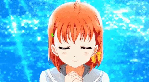 a girl with orange hair is smiling with her eyes closed and her hands folded in front of her face .