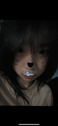 a close up of a girl 's face with a shark sticker on her mouth