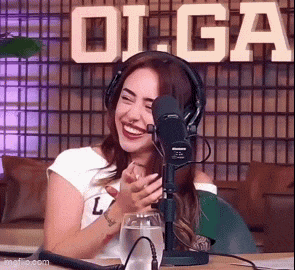 a woman wearing headphones is sitting in front of a microphone .