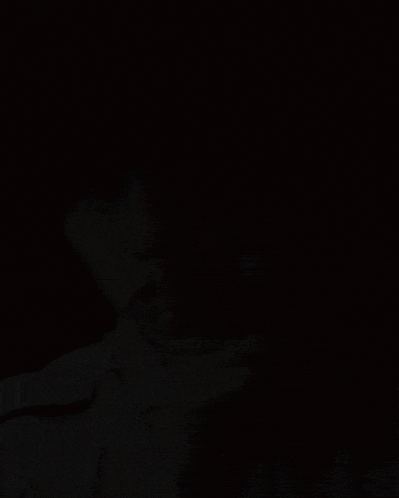 a young man holds his finger to his mouth