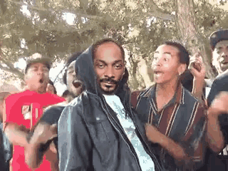 snoop dogg is wearing a hoodie while dancing with a group of people