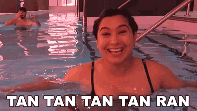a woman is smiling in a swimming pool with the words tan tan tan ran above her