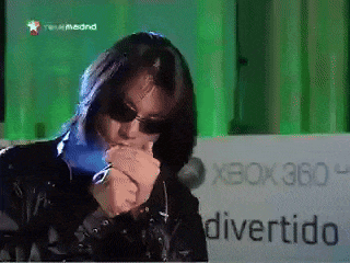 a woman smoking a cigarette in front of a sign that says xbox 360