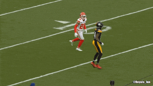 a football player with the number 14 on his jersey is running on the field