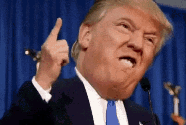 a man in a suit and tie is making a funny face and giving the middle finger
