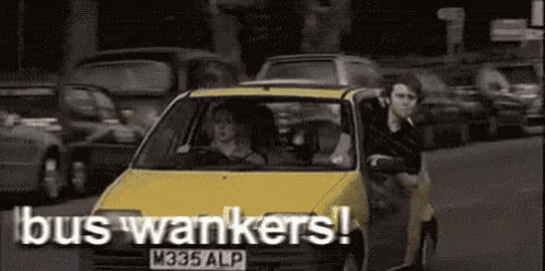 a yellow car with a license plate that says m335 alp is driving down a street with people in it .