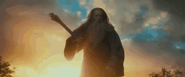 a man with a beard is holding a sword in front of a cloudy sky .