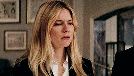 a woman with blonde hair is wearing a black suit and white shirt .