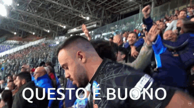 a crowd of people in a stadium with the words questo e buono in white