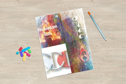 a colorful book titled amsterdam talk sits on a wooden table next to a pencil