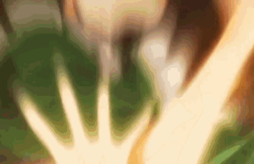 a blurred image of a person 's hand touching another person 's hand .