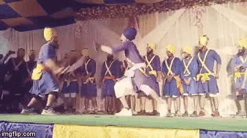 a group of men in blue uniforms are dancing on a stage with a watermark that says imgflip.com