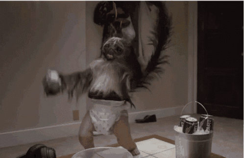 a baby in a diaper is standing in front of a bucket of bud light