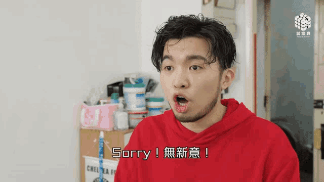 a man in a red hoodie says " sorry " in chinese