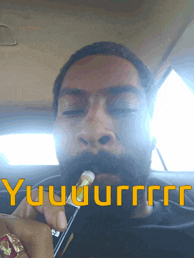 a man with a beard is smoking a cigarette in a car with the words yuuuurrr written on the bottom