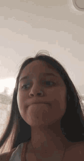 a girl with long hair is making a funny face with her mouth open