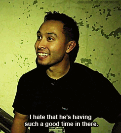 a man in a black shirt is smiling and saying i hate that he 's having such a good time in there