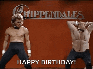 two men are dancing on a stage in front of a sign that says happy birthday .