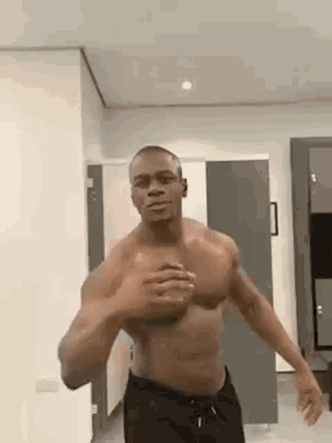 a shirtless man is standing in a room .