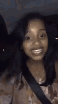 a woman is smiling in the back seat of a car .