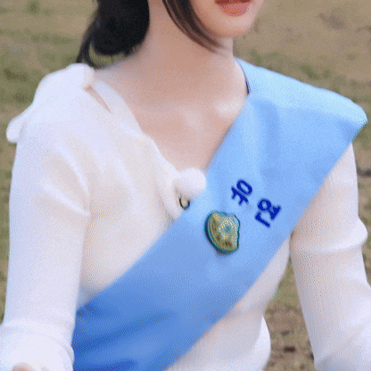 a woman wearing a blue sash with chinese writing
