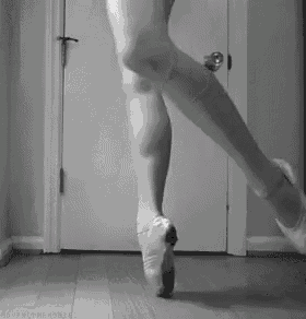 a black and white photo of a ballet dancer 's legs in pointe shoes .