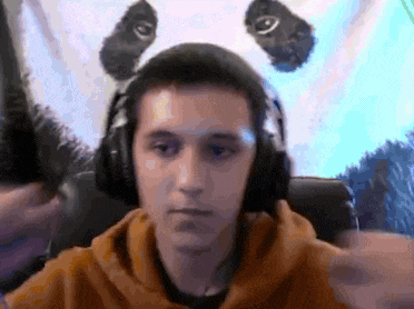 a man wearing headphones and a panda headband is sitting in front of a computer screen .