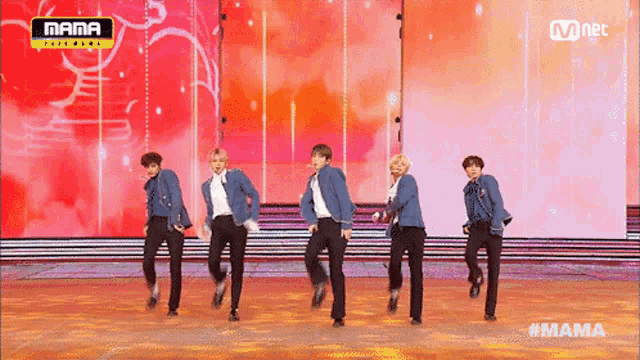 a group of men are dancing on a stage with a mnet logo in the corner