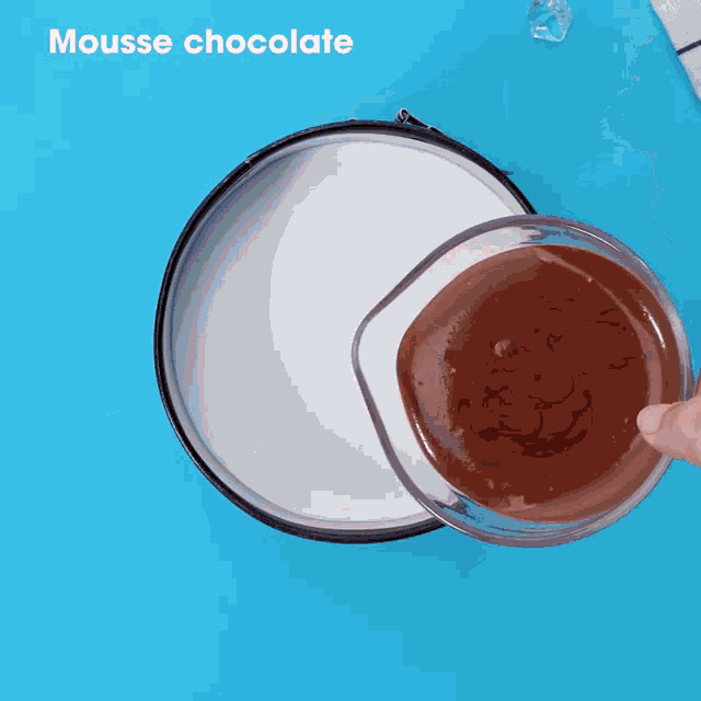 a person is pouring chocolate mousse into a pan of milk