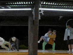 a man is carrying a woman in his arms while another man stands behind him