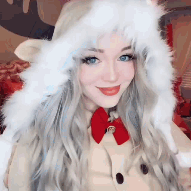 a woman with long blonde hair is wearing a santa hat and smiling