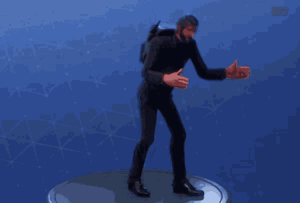 a man in a black suit is giving a thumbs up sign