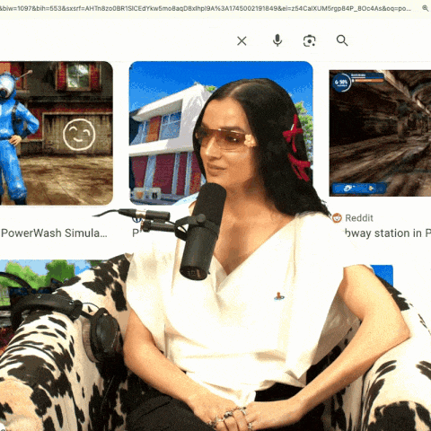 a woman sitting in a chair with a microphone in front of a screen that says powerwash simula...