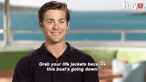 a man is smiling and saying grab your life jackets because this boat 's going down .