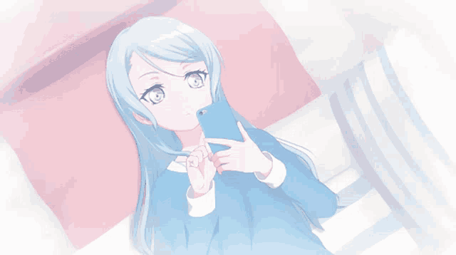 a girl with blue hair is laying on a bed looking at a cell phone