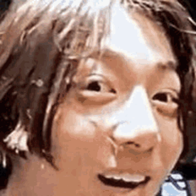 a close up of a person 's face with their mouth open and a slight smile on their face .