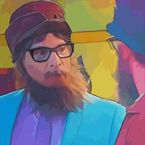 a man with glasses and a beard looks at another man